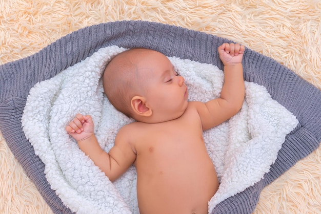 Bébé dort sur un petit pain en laine, vue de dessus