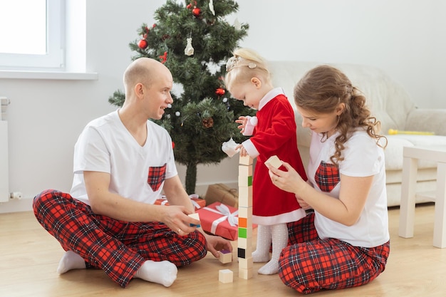 Bébé enfant avec appareil auditif et implant cochléaire s'amusant avec les parents dans la salle de noël div sourd