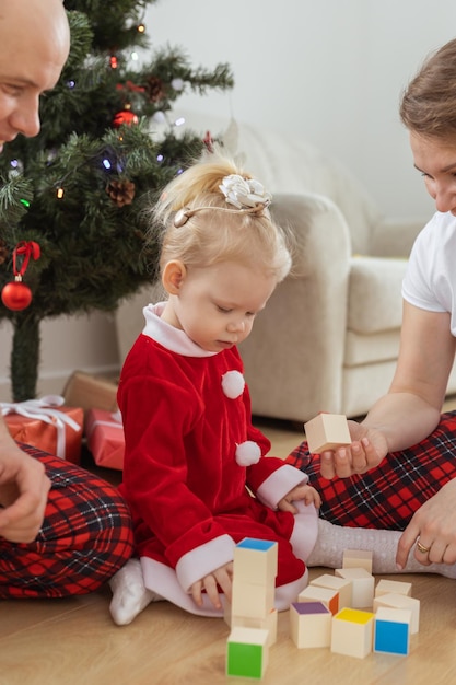 Bébé enfant avec appareil auditif et implant cochléaire s'amusant avec les parents dans la salle de Noël Diversité sourde et santé et diversité