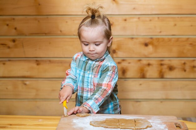 Bébé enfant garçon cuisine jouant avec de la farine dans une cuisine en bois