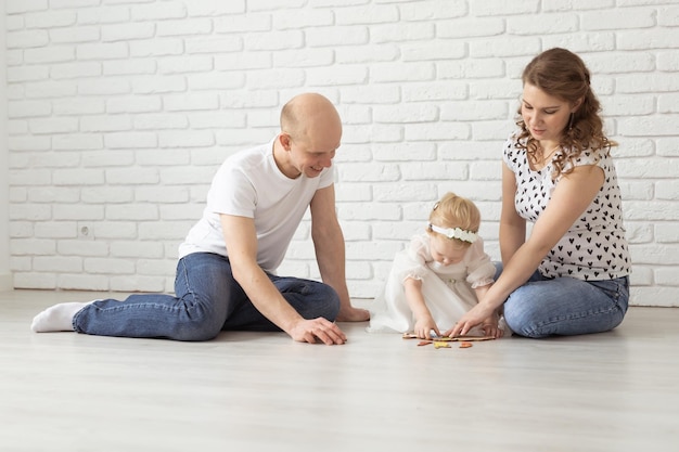 Bébé enfant avec prothèses auditives et implants cochléaires joue avec les parents sur le sol sourd et réhabilité