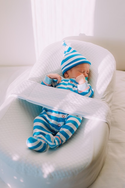 Le bébé est allongé dans un cocon d'espace de copie Le bébé a 03 mois