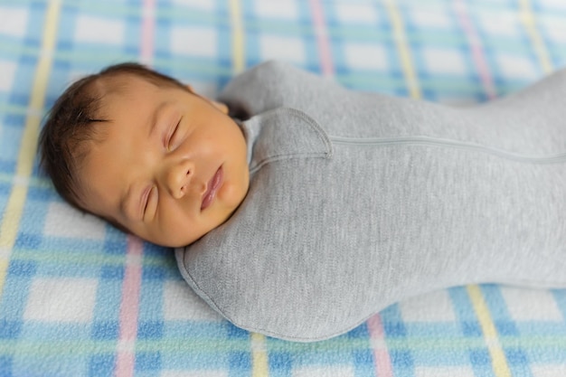 Le bébé est allongé dans un cocon sur un lit bébé Il dort doucement et rêve