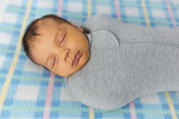 Le bébé est allongé dans un cocon sur un lit bébé Il dort doucement et rêve