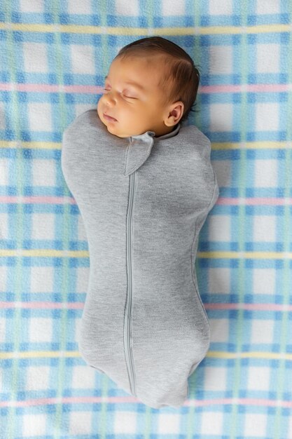 Le bébé est allongé dans un cocon sur un lit bébé Il dort doucement et rêve