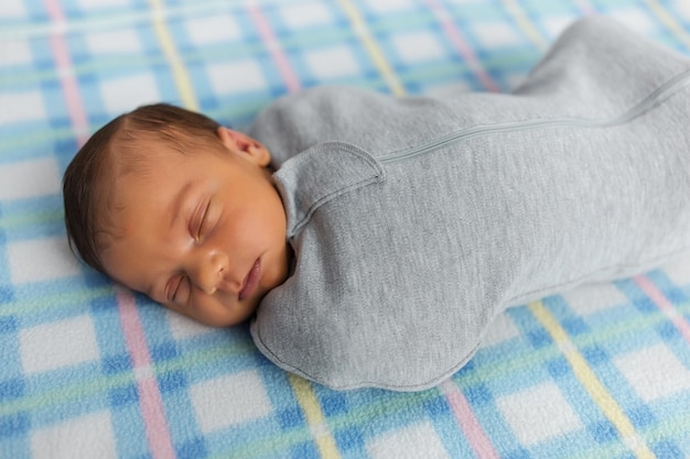 Le bébé est allongé dans un cocon sur un lit bébé Il dort doucement et rêve