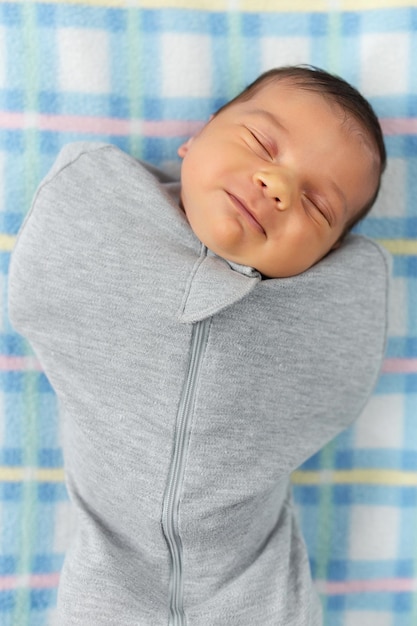 Le bébé est allongé dans un cocon sur un lit bébé Il dort doucement et rêve