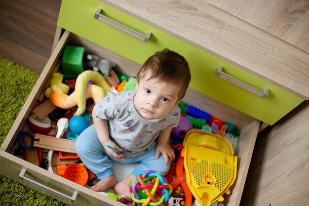 Bébé est assis au milieu des jouets