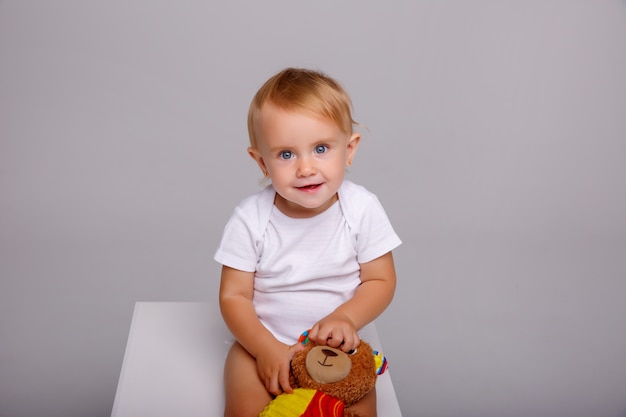 bébé est assis sur un cube en studio blanc,