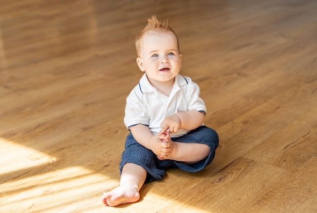 Le bébé est assis par terre et regarde en haut.