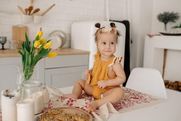 Bébé est assis sur une table dans une cuisine scandinave