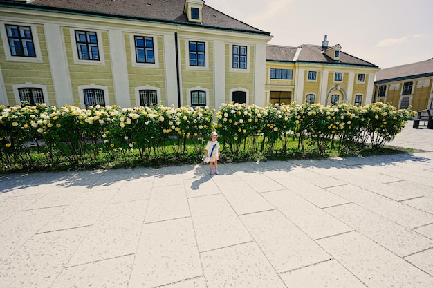 Bébé fille debout près de rosiers jaunes au château de Schonbrunn à Vienne Autriche