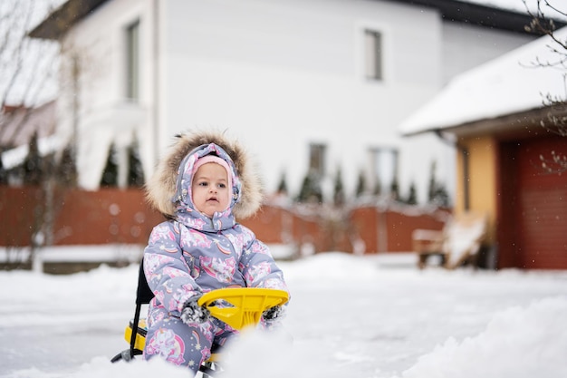 Bébé fille jouer à l'extérieur dans la neige profitez d'une balade en traîneau