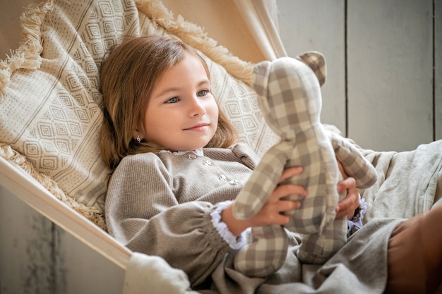 Bébé fille, à la maison joue avec un ours en peluche