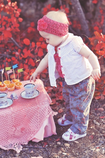 Bébé fille porter des vêtements casula au thé avec des décorations en plein air