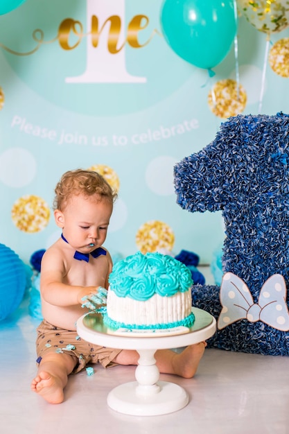 Bébé garçon jouant avec un gâteau pendant la fête d'anniversaire de gâteau smash