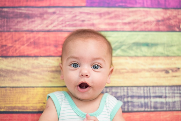 Bébé garçon en studio avec fond en bois coloré