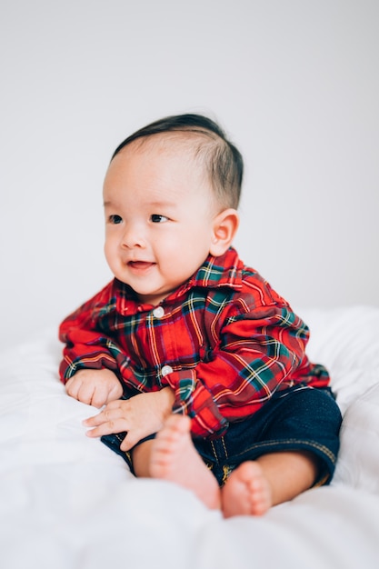 Bébé heureux de 4 mois. Petit garçon dans une chemise rouge. Portrait d'enfants. Bébé élégant à la mode.