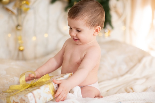 Bébé heureux dans un chapeau de Noël avec un cadeau