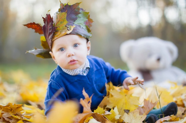 Bébé heureux dans le parc d'automne joue avec les feuilles