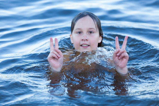 Bébé heureux nage et joue dans l'eau