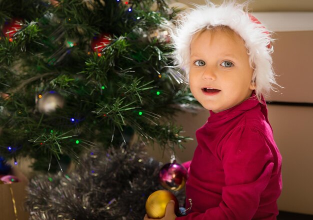 Bébé heureux près de l'arbre de Noël