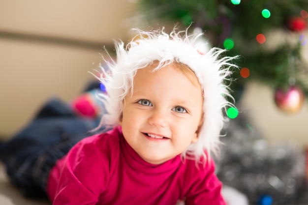 Bébé heureux près de l'arbre de Noël