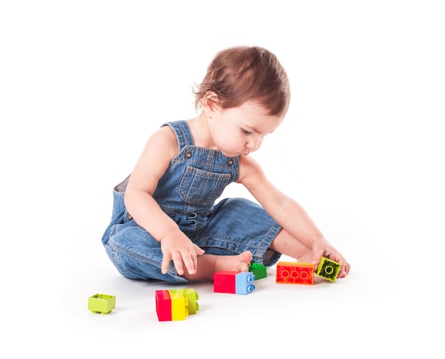 Bébé jouant avec des blocs de couleur isolated on white