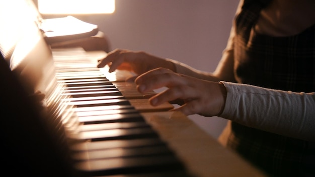 Un bébé jouant du piano sur la leçon de musique belle lumière du soleil