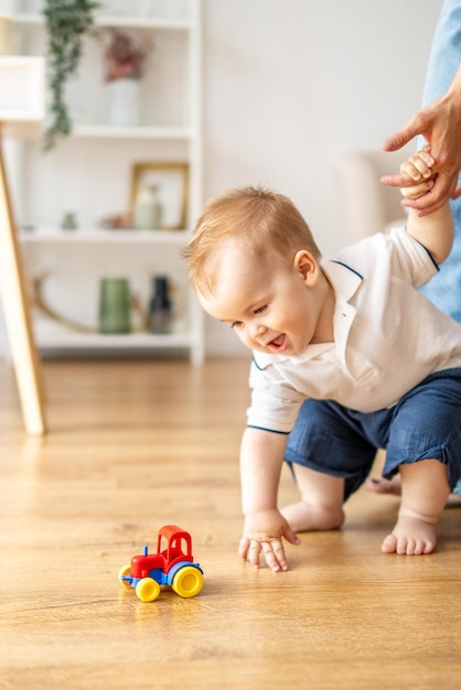 Un bébé joue avec un camion jouet sur le sol