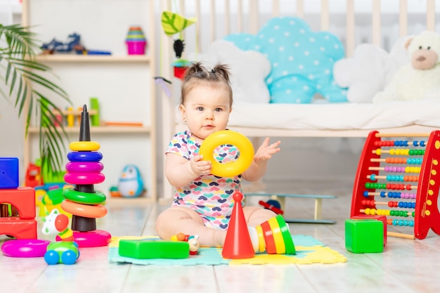 Le bébé joue à la maison dans la crèche Jouets pour petits enfants Un enfant avec des jouets éducatifs Développement précoce