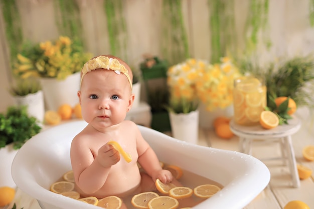 Bébé mange avec des citrons et boit de la limonade dans le bain