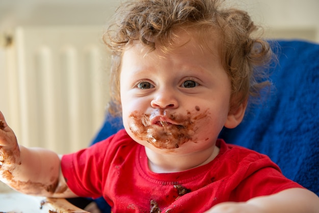 Bébé mange un gâteau au chocolat