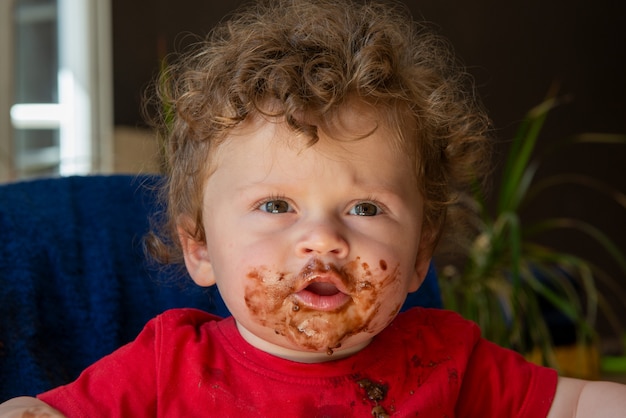 Bébé mange un gâteau au chocolat