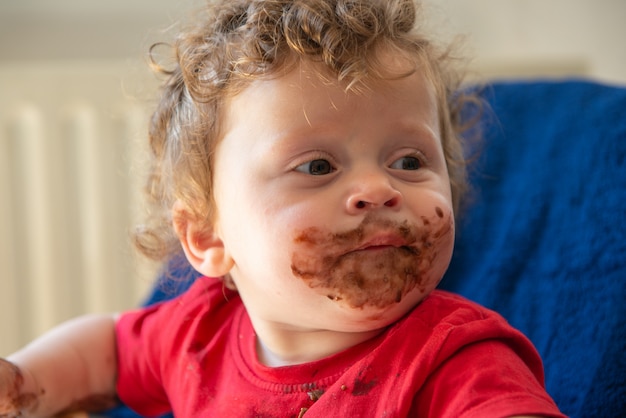 Bébé mange un gâteau au chocolat