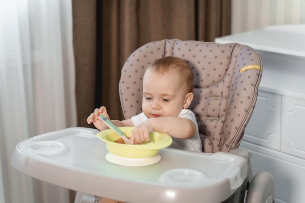 Le bébé mange à la table des enfants jusqu'à un an