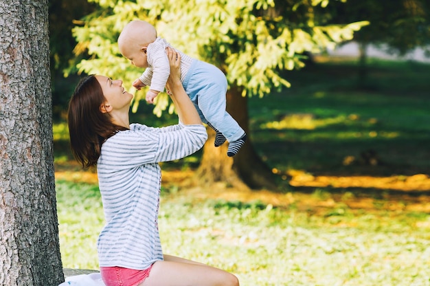 Bébé et mère sur la nature dans le parc le jour de l'été. Héhé, marchant à l'extérieur