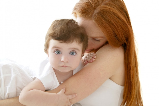 Bébé et mère rousse câlin sur blanc