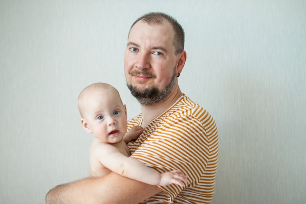 Bébé mignon sur les bras de son grand père fort.