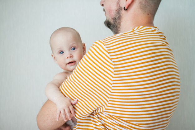 Bébé mignon sur les bras de son grand père fort.