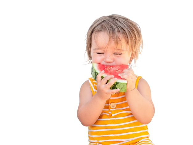 Bébé mignon mangeant la pastèque juteuse rouge isolé sur fond blanc