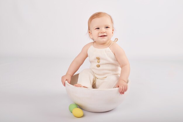 Bébé mignon avec des oeufs de Pâques peints