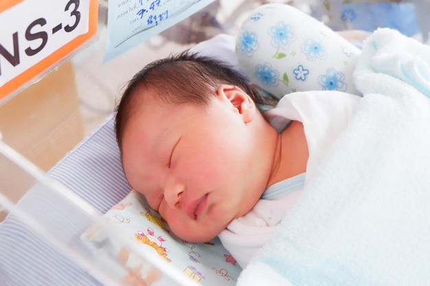 Un bébé mignon qui dort sur le lit.