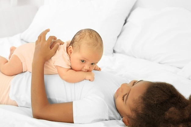 Bébé mignon et sœur aînée sur le lit