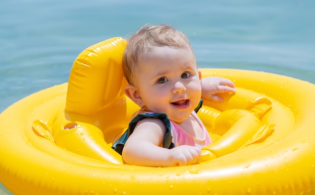 Bébé nage dans un anneau en caoutchouc sur la mer