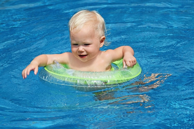 Bébé nageant dans l'eau bleue de la piscine