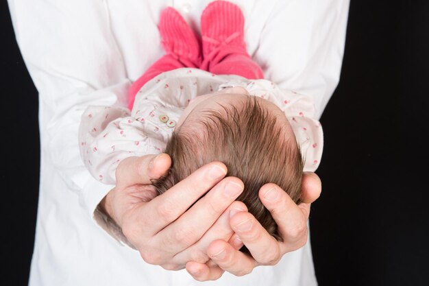 Photo bébé nouveau-né dormant sur les mains de son père