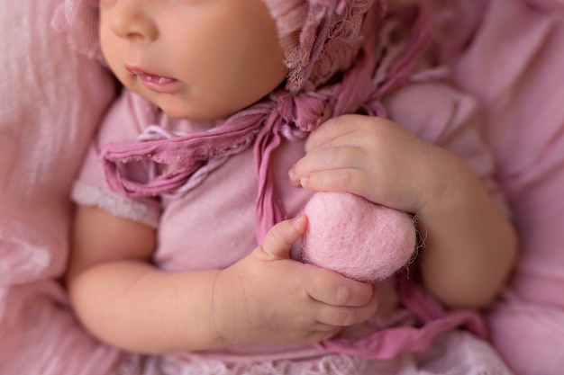 Photo bébé nouveau-né fille dormant dans un panier rétro avec des fleurs roses de jardin rose