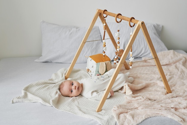 Un bébé nouveau-né ment et joue avec des jouets éducatifs. Bonne maternité et paternité. Maternité et clinique. Fête des pères et mères. Développement de la petite enfance.