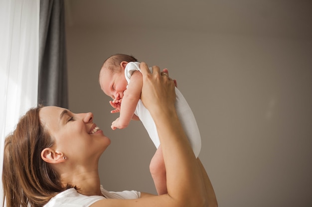 Bébé nouveau-né mignon dormant dans les bras de la mère. Maternité.